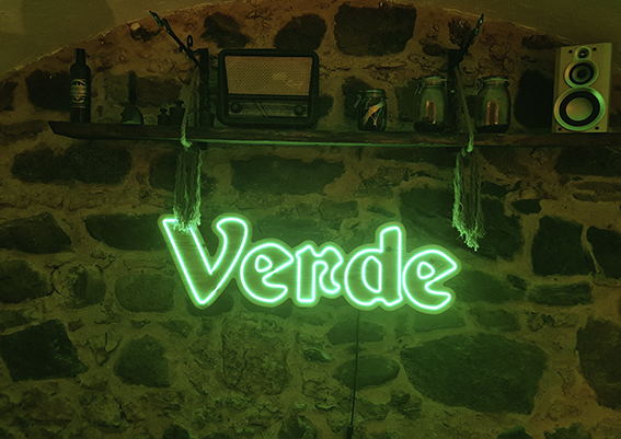 Neon Verde na kamiennej ścianie